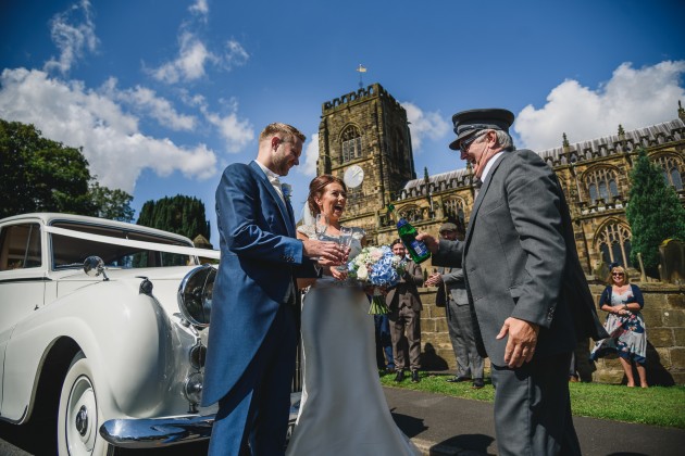 Stan-Seaton-Photography-bride-and-groom-opening-champagne-at-the-church