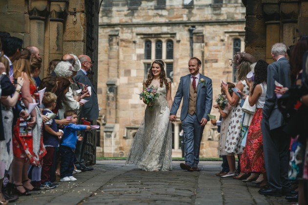 052 Durham-Castle-Wedding-Photographer-Stan-Seaton-bride-and-groom-walking-through-the confetti.JPG